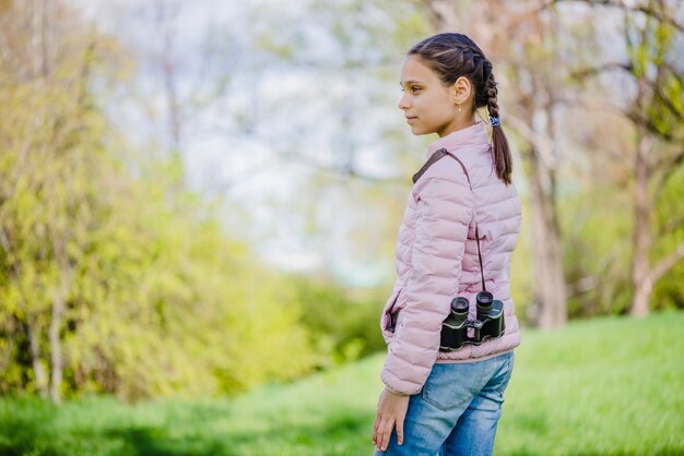 Mooi meisje poseren met haar verrekijker in het park