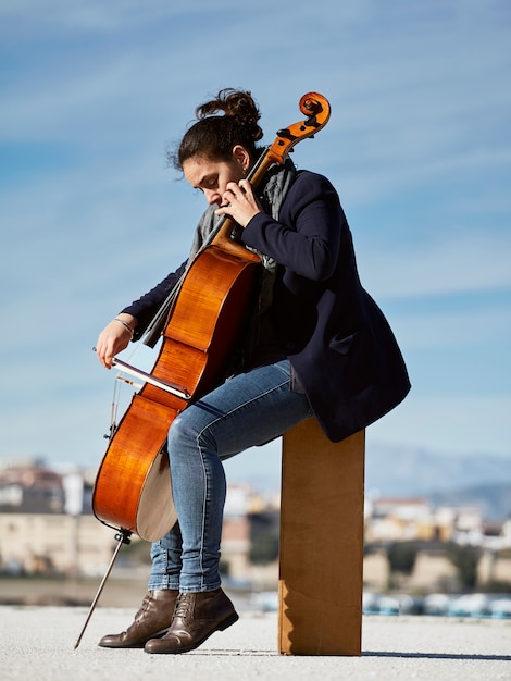 mooi meisje speelt cello met passie in een concrete omgeving