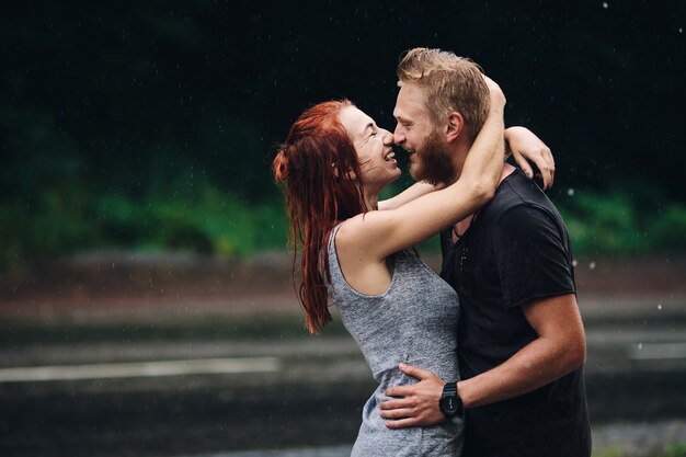 Mooi paar knuffelen buiten in de regen