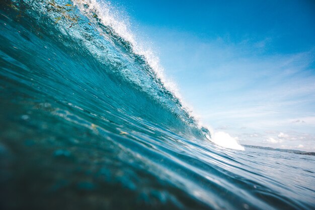 Mooi schot van een golf die vorm krijgt onder de duidelijke blauwe hemel die in Lombok, Indonesië wordt gevangen