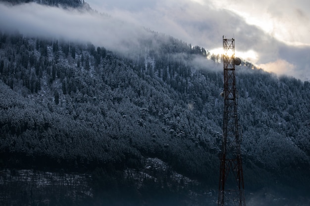 Gratis foto mooi schot van een radiotoren op een besneeuwde bosachtergrond