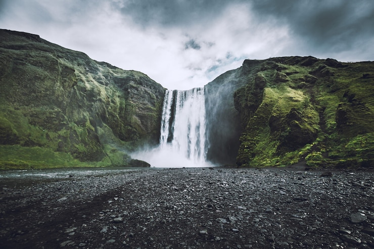Gratis Foto mooi schot van een waterval die uit bergen naar beneden komt