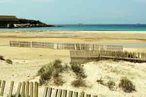 Gratis foto mooi schot van kust vol houten hekken op het zand