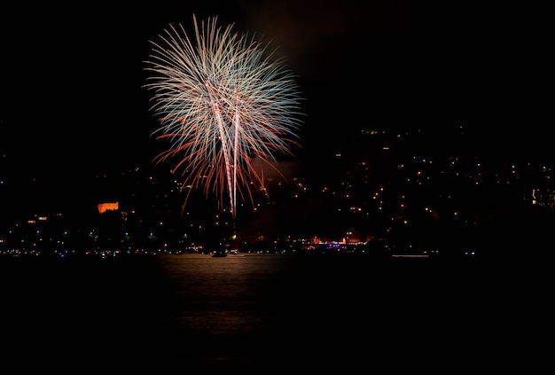 Mooi schot van rood vuurwerk boven een meer in Zwitserland 's nachts