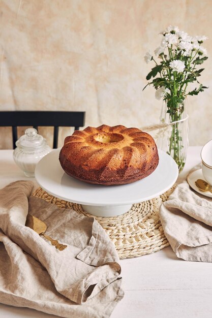 Mooi shot van een heerlijke ringcake op een witte plaat en een witte bloem erbij