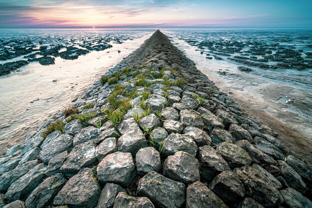 Mooi shot van een rotsachtig strand tijdens de zonsondergang