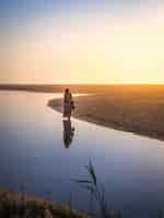 Gratis foto mooi shot van een vrouw die tijdens zonsondergang op het strand loopt