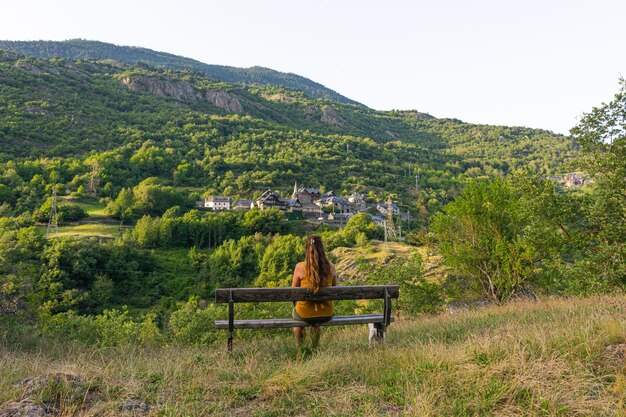 Mooi shot van een vrouw zittend op de bank met uitzicht op een berglandschap