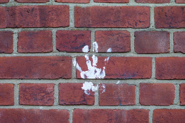 Mooi shot van een witte handafdruk op een bakstenen muur