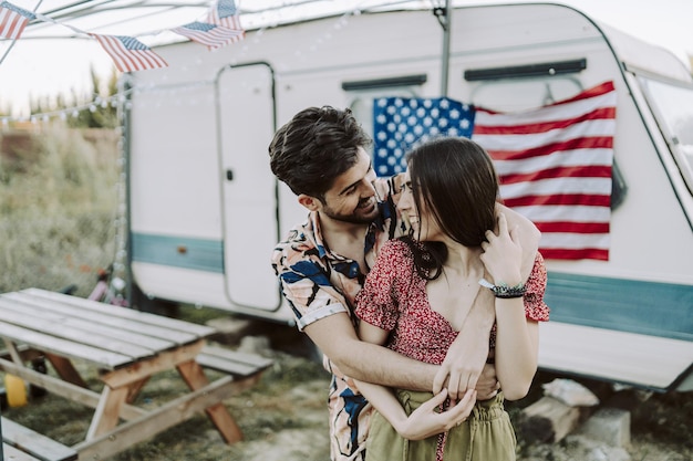 Gratis foto mooi spaans koppel knuffelen op amerikaanse vlag