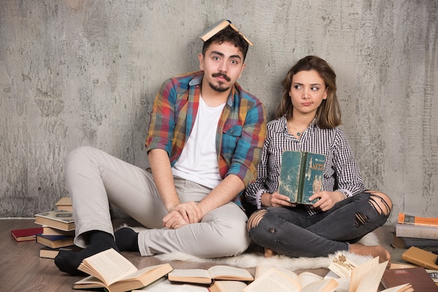 mooi stel zittend op de vloer met veel boeken