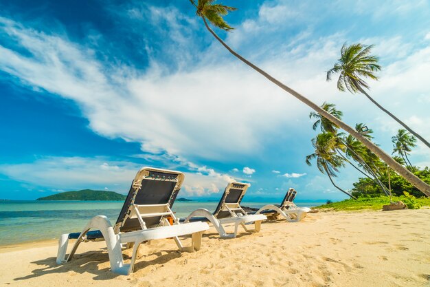 Mooi tropisch strand en zee met kokosnotenpalm en stoel in paradijseiland