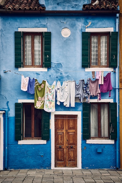 Mooi verticaal symmetrisch schot van een blauw gebouw in de voorsteden met kleren die op een kabel hangen