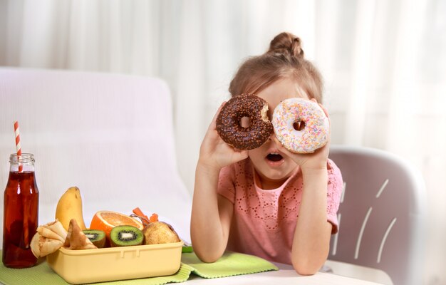 Mooi vrolijk meisje eten van een donut