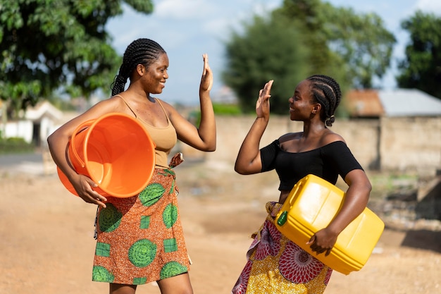 Mooie Afrikaanse vrouwen die plezier hebben tijdens het halen van water