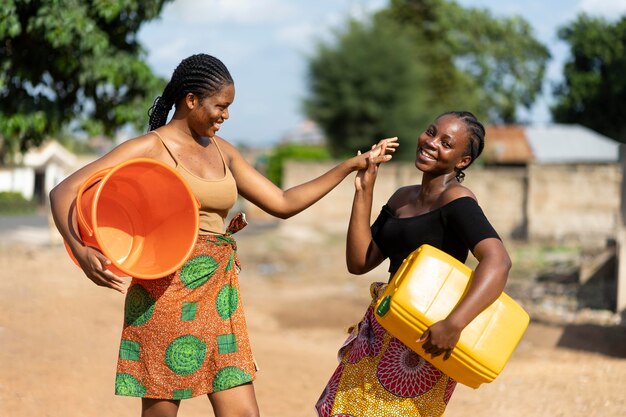 Mooie Afrikaanse vrouwen die plezier hebben tijdens het halen van water