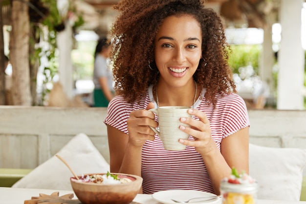 Gratis foto mooie afro-amerikaanse vrouw in café