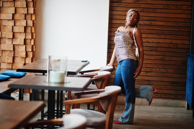 Mooie afro-amerikaanse vrouw met dreadlocks in luipaardoutfit in café Mooi cool, modieus zwart jong meisje binnen