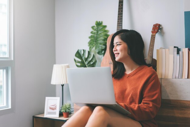 Mooie Aziatische jonge vrouw creatieve freelancer bezig met laptopcomputer werken vanuit huis Concept