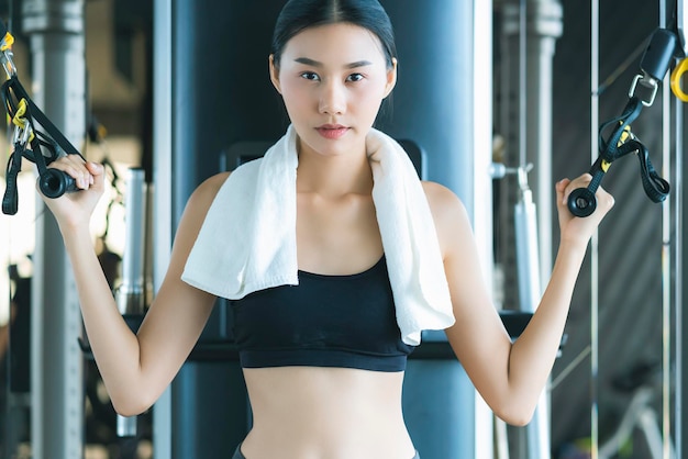 Mooie aziatische sportvrouw training met gewichtsmachine om te oefenen in fitness mooie vrouw tilt zware halter op terwijl ze in de fitness traint Sportconcept bodu bouwer gezonde levensstijl