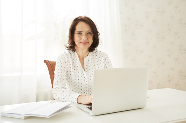 Mooie Aziatische volwassen vrouw met behulp van draagbare laptopcomputer