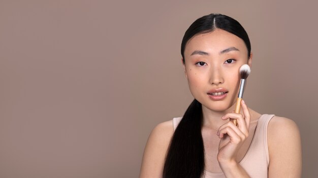 Mooie Aziatische vrouw die make-up toepast