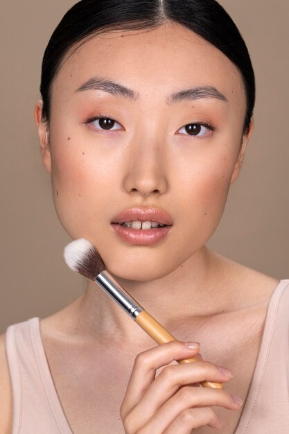 Mooie Aziatische vrouw die make-up toepast