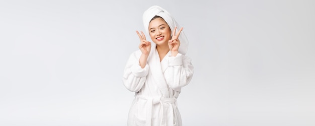 Mooie Aziatische vrouw die vredesteken of twee vingers toont met een gelukkig gevoel Geïsoleerd op witte achtergrond