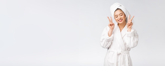 Mooie Aziatische vrouw die vredesteken of twee vingers toont met een gelukkig gevoel Geïsoleerd op witte achtergrond