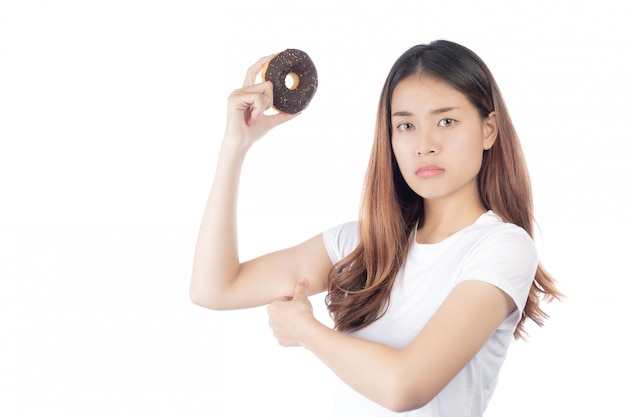 Mooie Aziatische vrouw met een gelukkige glimlach, die doughnut in hand houdt