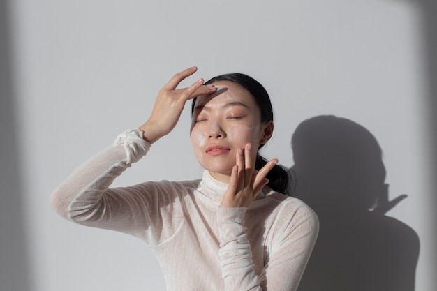 Mooie Aziatische vrouw poseren met gezichtscrème