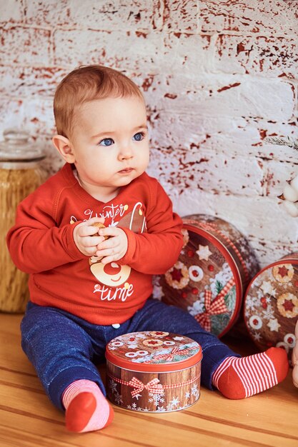 Mooie baby zit aan de tafel met een noot en kijkt opzij