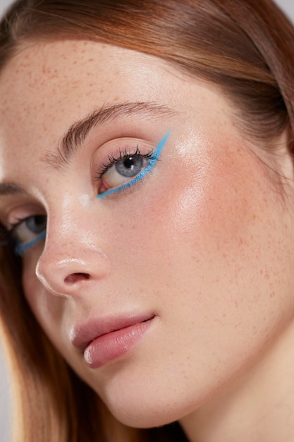 Gratis foto mooie blanke vrouw met blauwe eyeliner