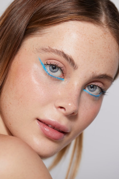 Gratis foto mooie blanke vrouw met blauwe eyeliner