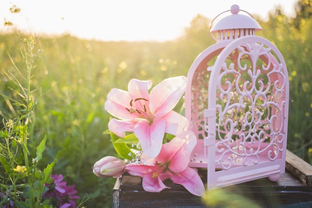 Gratis foto mooie bloemen naast een decoratieve lantaarn