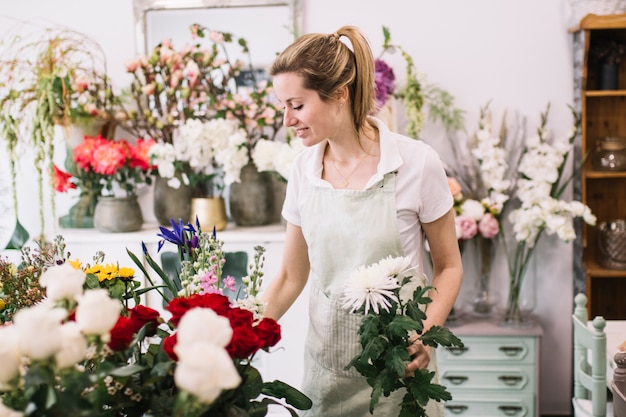 Mooie bloemist die bloemen in winkel schikken