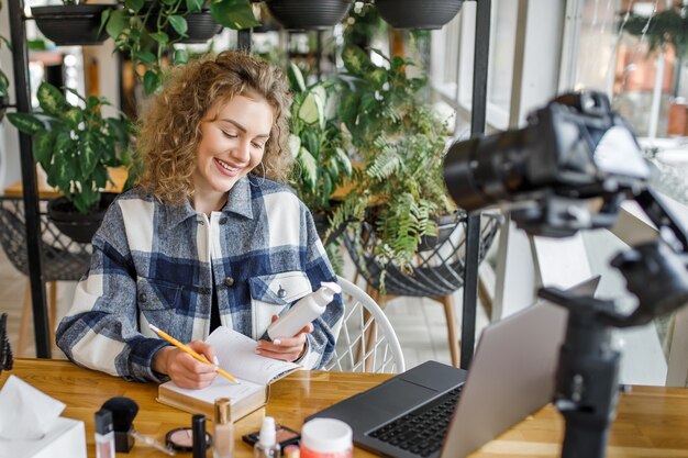 Mooie blonde influencer die nieuwe producten test op de camera