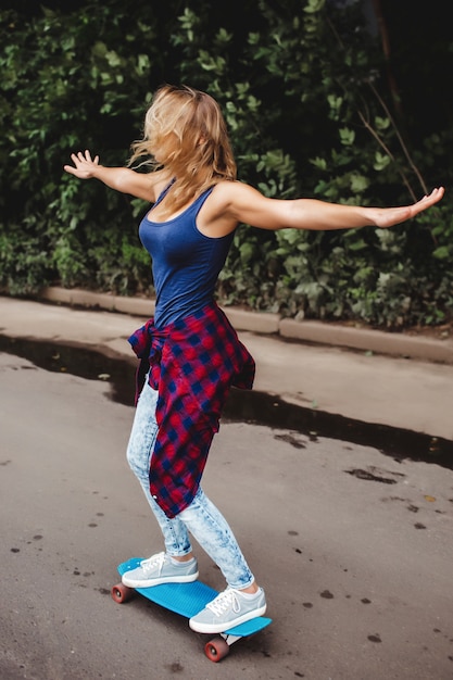 Gratis foto mooie blonde schaatsen in het park