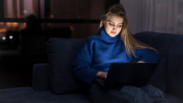 Mooie blonde vrouw die bij laptop werkt