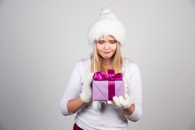 Mooie blonde vrouw die naar haar cadeau kijkt.