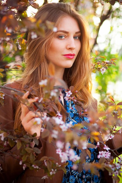 Mooie blonde vrouw in het park op een warme lentedag