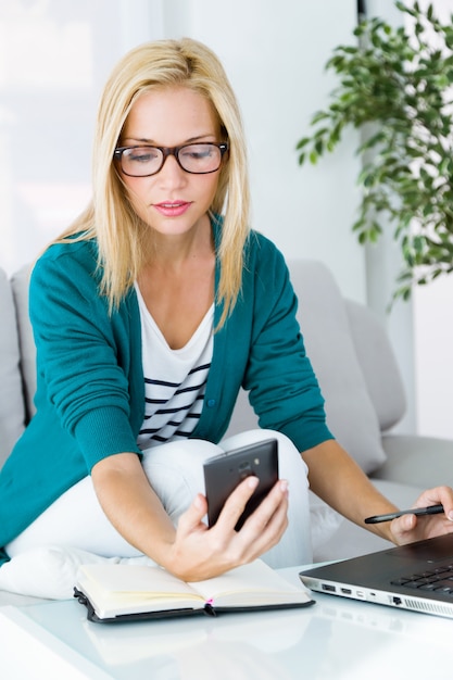 Mooie blonde vrouw met behulp van telefoon