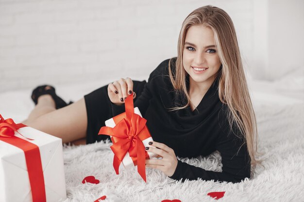 Mooie blonde vrouw met geschenken binnen