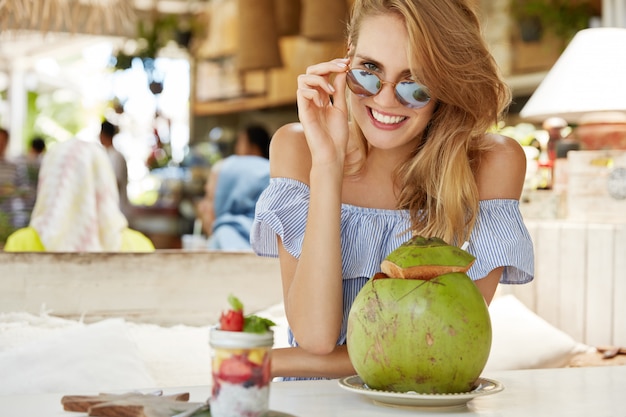 Mooie blonde vrouw zitten in café