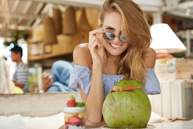 Mooie blonde vrouw zitten in café