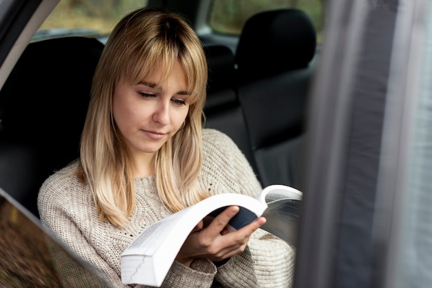 Mooie blonde vrouwenlezing in auto