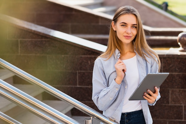 Mooie blondevrouw die een tablet houden