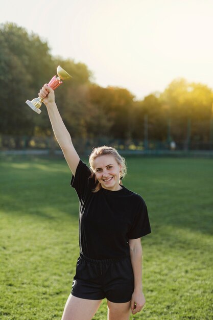 Mooie blondevrouw die een trofee opheffen