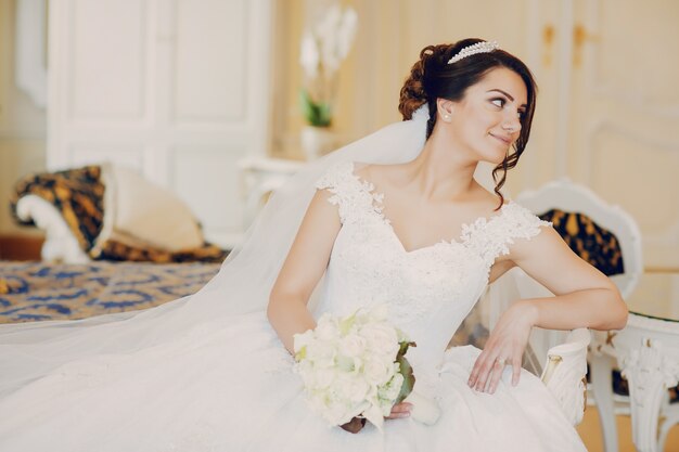 mooie bruid in een prachtige witte jurk en een kroon op zijn hoofd