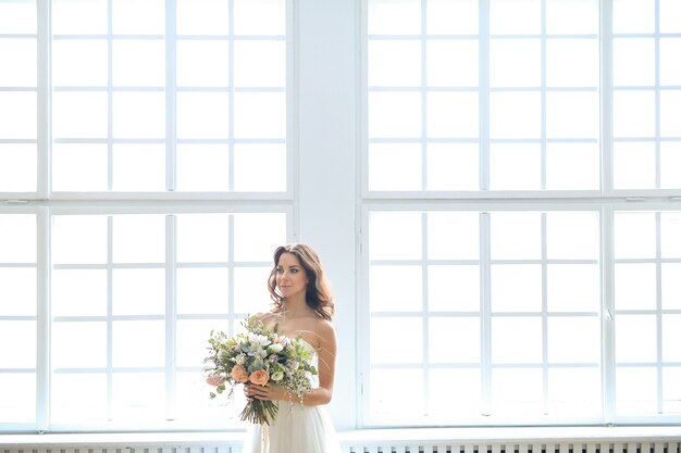 Mooie bruid vrouw in elegante trouwjurk met boeket bloemen